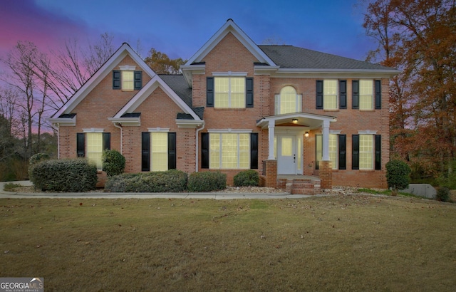 view of front of home with a front lawn and brick siding