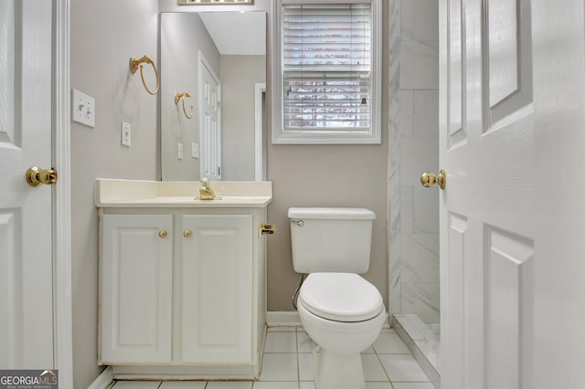 bathroom featuring toilet, tile patterned flooring, baseboards, and vanity