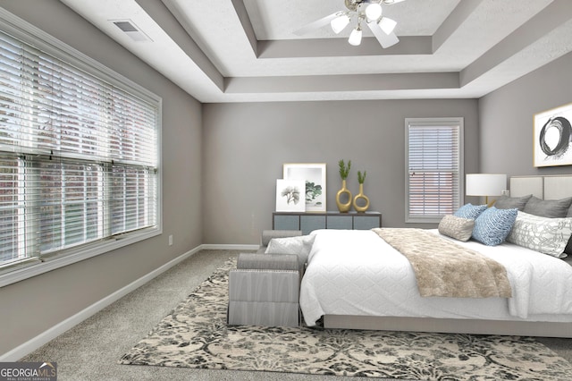 bedroom with visible vents, baseboards, a raised ceiling, and carpet flooring