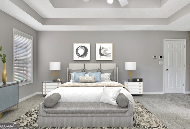 bedroom with carpet floors, a tray ceiling, and baseboards