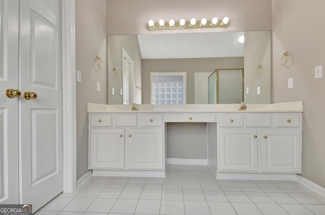 bathroom featuring tile patterned floors, vanity, a shower stall, and baseboards