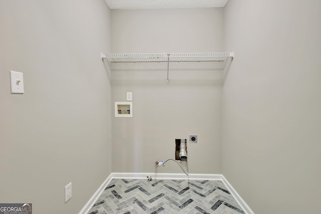 laundry area with laundry area, hookup for an electric dryer, gas dryer hookup, washer hookup, and baseboards