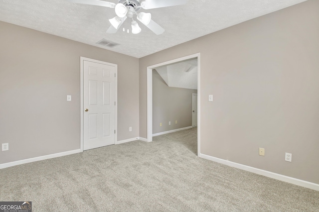 unfurnished bedroom featuring carpet floors, visible vents, a ceiling fan, a textured ceiling, and baseboards