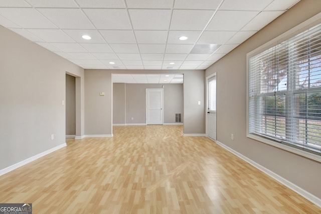 unfurnished living room with baseboards, recessed lighting, light wood finished floors, and a paneled ceiling