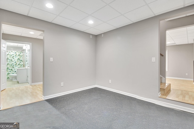 spare room with stairs, baseboards, a drop ceiling, and recessed lighting