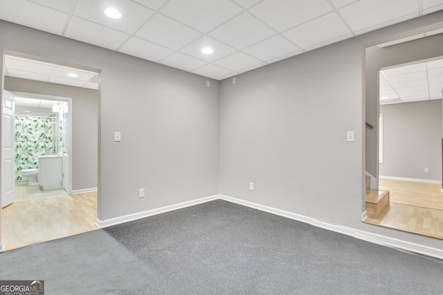 spare room featuring recessed lighting, stairs, a drop ceiling, and baseboards