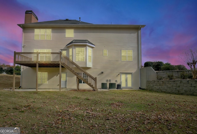 back of house with a chimney, a yard, stairway, a patio, and a wooden deck
