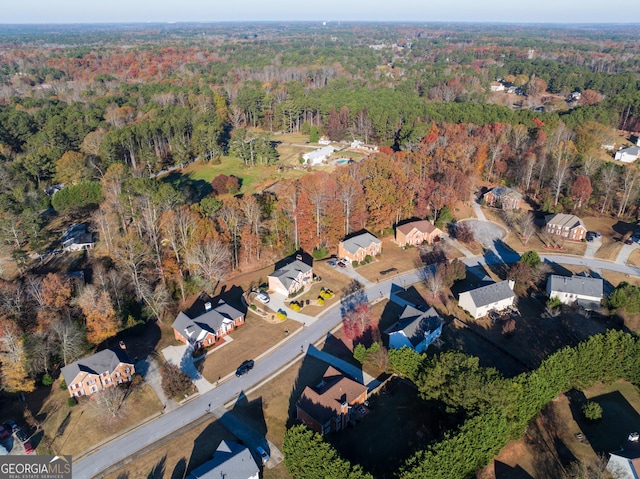 drone / aerial view featuring a wooded view and a residential view