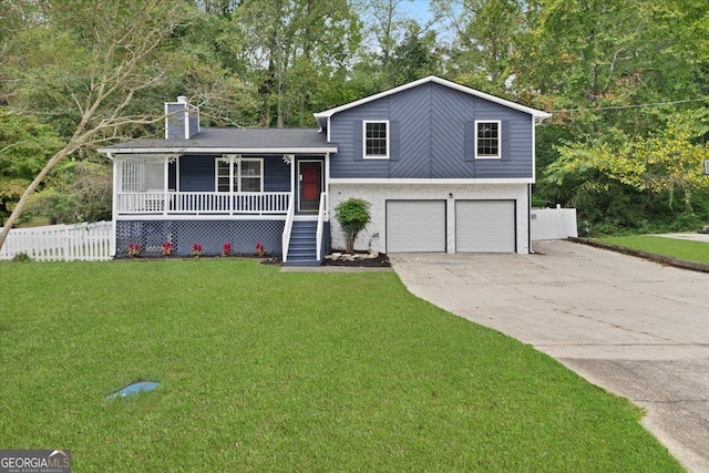 tri-level home with a porch, a garage, and a front lawn