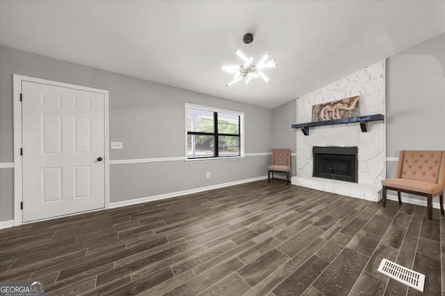 unfurnished living room featuring lofted ceiling, a fireplace, and dark hardwood / wood-style floors