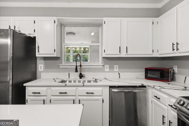 kitchen with white cabinets, stainless steel appliances, light stone countertops, and sink