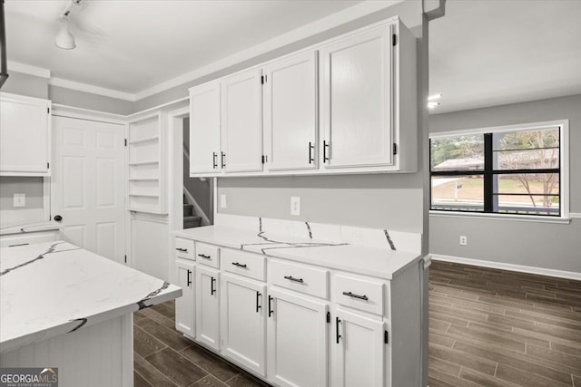 kitchen with dark hardwood / wood-style floors, white cabinetry, and light stone counters