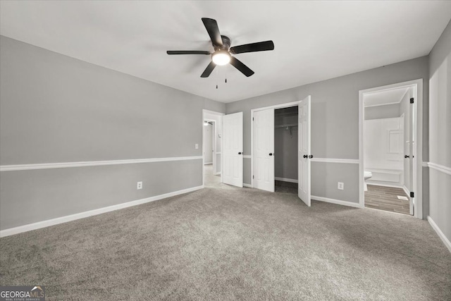 unfurnished bedroom with carpet flooring, a closet, ensuite bath, and ceiling fan