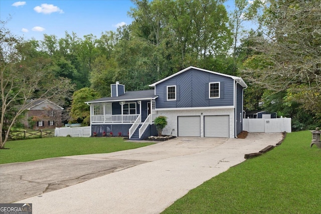 tri-level home with a front lawn, covered porch, and a garage