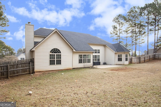 rear view of property with a fenced backyard, central air condition unit, a shingled roof, a chimney, and a patio area