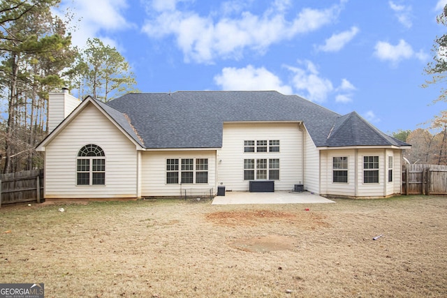 rear view of house with a patio area, a fenced backyard, a chimney, and a shingled roof