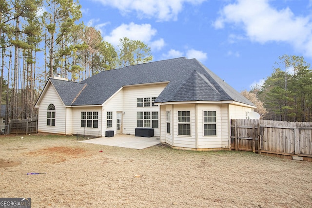 back of house featuring a patio, a shingled roof, and a fenced backyard