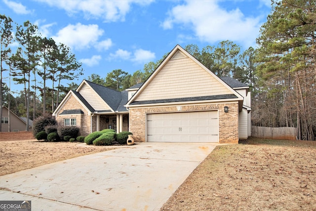 traditional home featuring concrete driveway, brick siding, an attached garage, and fence