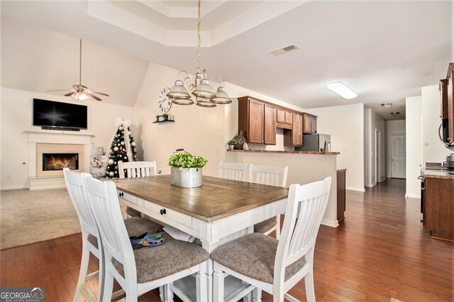 dining room with vaulted ceiling, dark hardwood / wood-style floors, and ceiling fan with notable chandelier