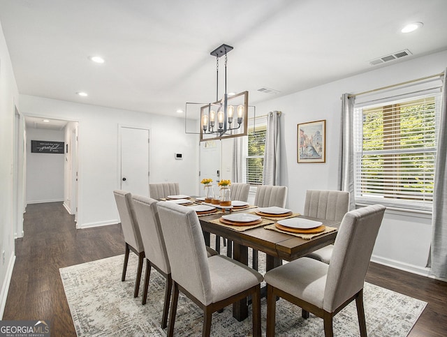 dining room featuring a chandelier and dark wood-type flooring