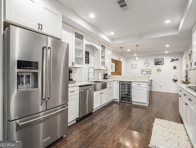 kitchen featuring beverage cooler, stainless steel appliances, dark hardwood / wood-style flooring, pendant lighting, and white cabinets