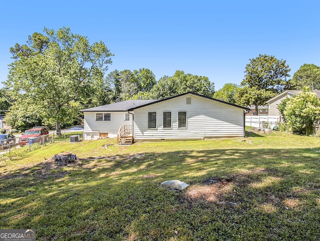 rear view of house with a yard and cooling unit