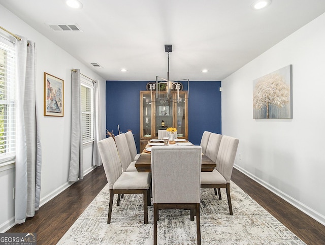 dining area with a notable chandelier and dark hardwood / wood-style flooring