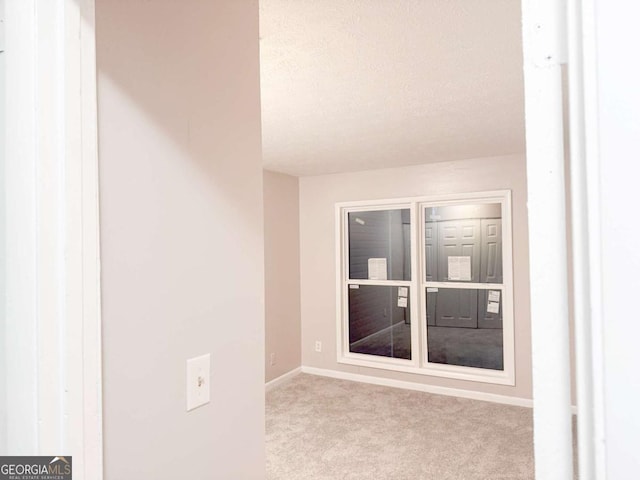 carpeted empty room with a textured ceiling