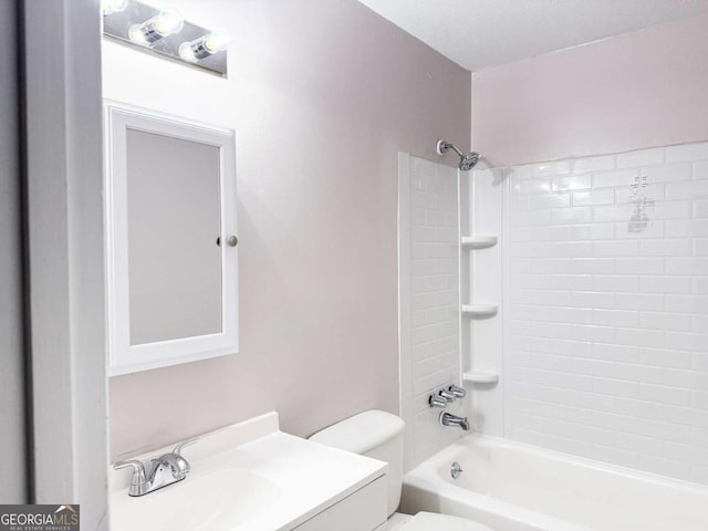 full bathroom featuring toilet, vanity, a textured ceiling, and tiled shower / bath