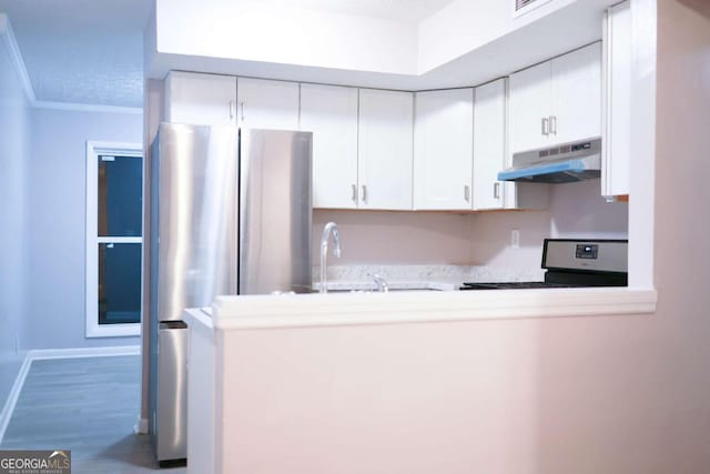 kitchen with white cabinets, crown molding, wood-type flooring, and stainless steel appliances