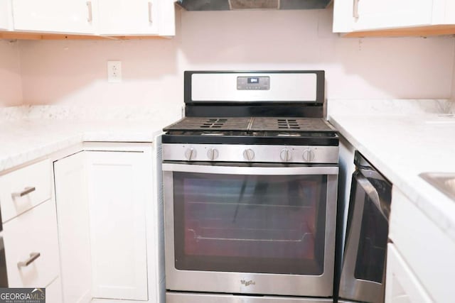 kitchen with white cabinets, appliances with stainless steel finishes, and exhaust hood