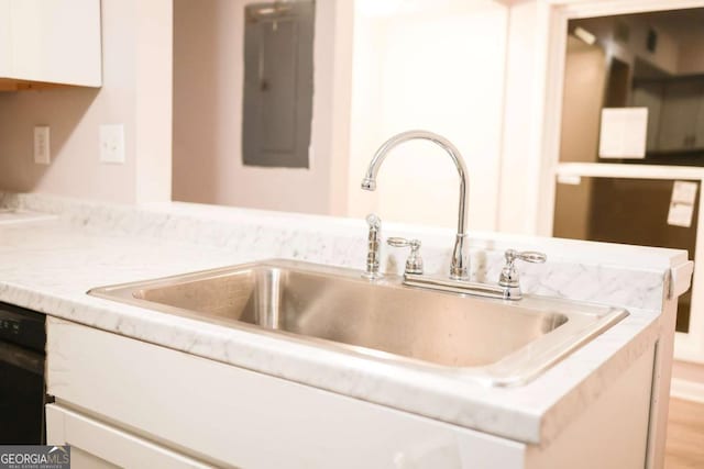 room details with dishwasher, white cabinetry, and sink