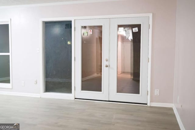 interior space featuring french doors, light hardwood / wood-style floors, and ornamental molding