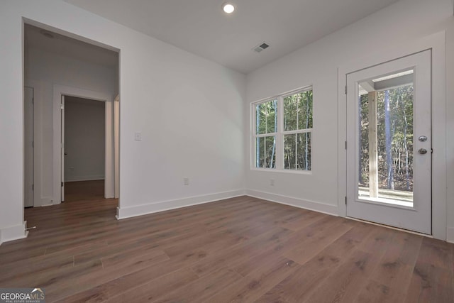 empty room featuring recessed lighting, dark wood finished floors, visible vents, and baseboards