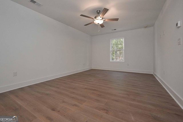 unfurnished room featuring baseboards, visible vents, ceiling fan, and dark wood-type flooring