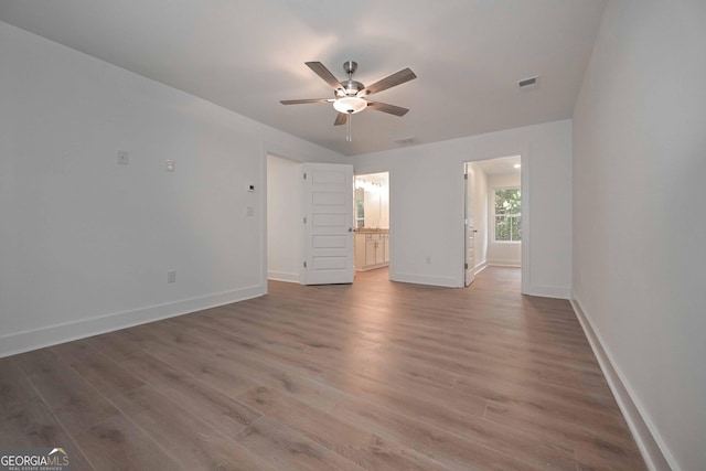 unfurnished bedroom with ceiling fan, connected bathroom, wood finished floors, visible vents, and baseboards