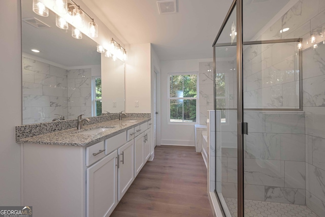 full bathroom with a stall shower, visible vents, a sink, and wood finished floors