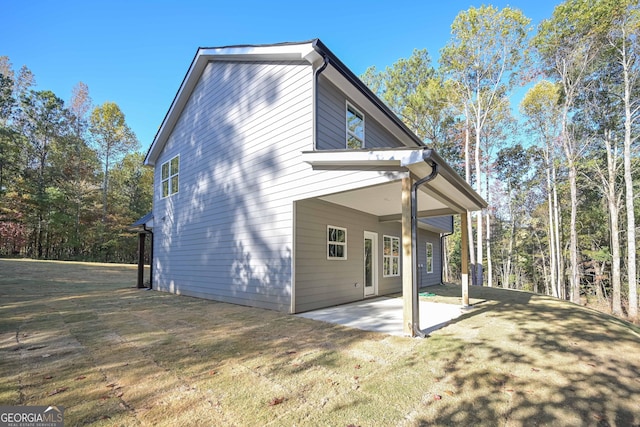 rear view of house featuring a patio area and a lawn