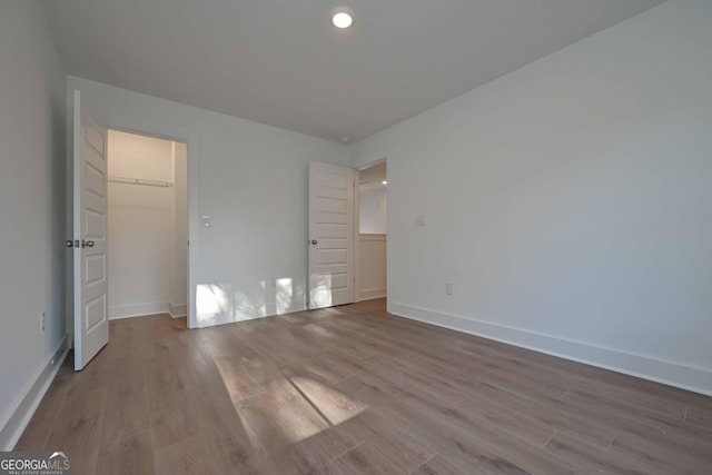 unfurnished bedroom with light wood-type flooring, baseboards, and recessed lighting