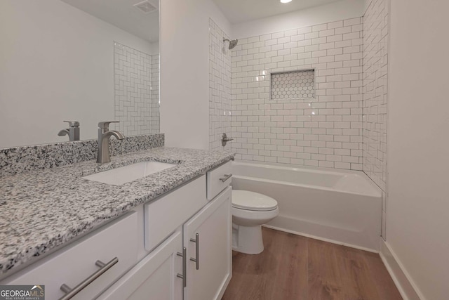 full bathroom featuring visible vents, shower / bathing tub combination, toilet, vanity, and wood finished floors