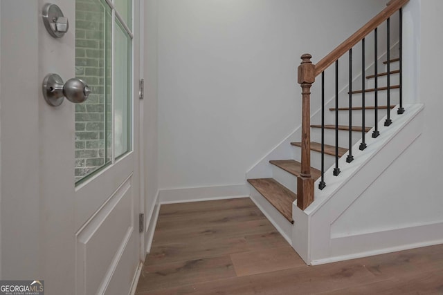 staircase with baseboards and wood finished floors