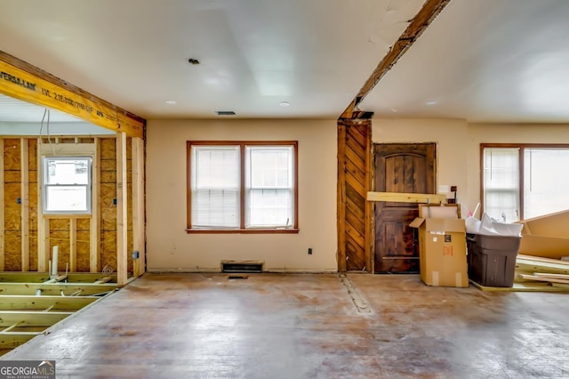 unfurnished living room with concrete flooring