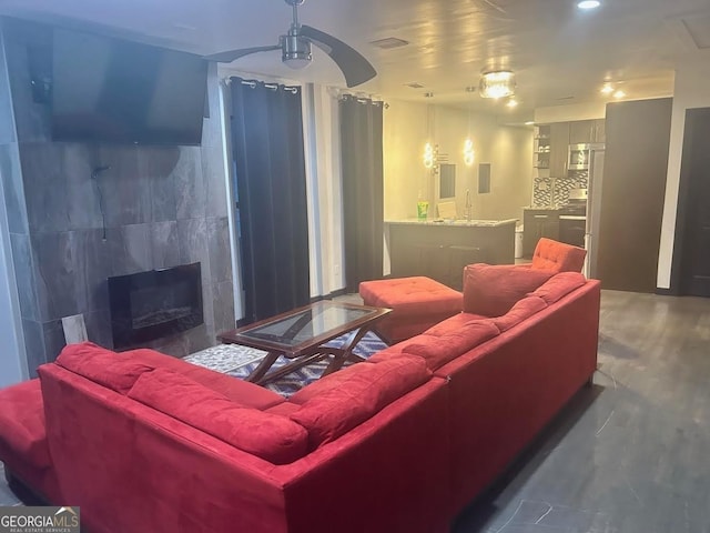 home theater room with a fireplace, ceiling fan, and sink