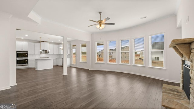 unfurnished living room with a fireplace, ceiling fan, dark hardwood / wood-style flooring, and ornamental molding