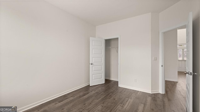 unfurnished bedroom with a closet and dark hardwood / wood-style floors