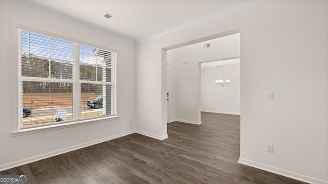 spare room with a notable chandelier, dark hardwood / wood-style floors, and ornamental molding