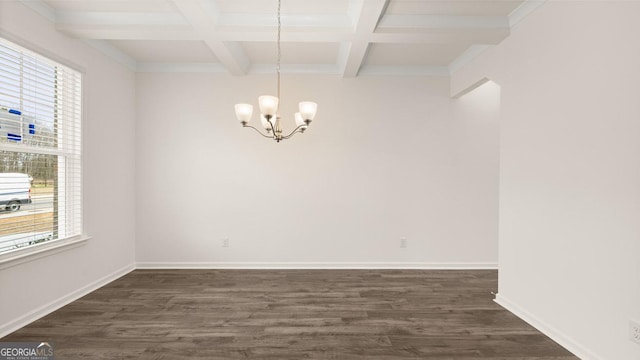 unfurnished room featuring plenty of natural light, dark hardwood / wood-style floors, beam ceiling, and an inviting chandelier