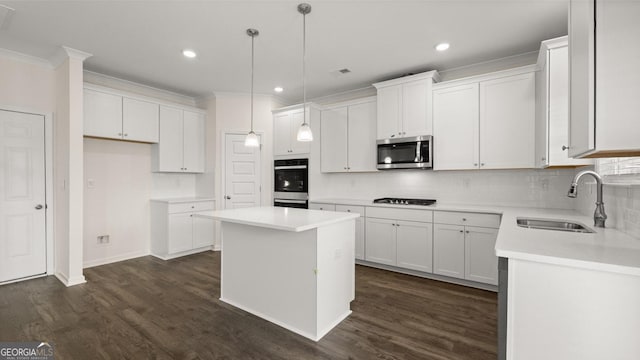 kitchen featuring white cabinetry, sink, a kitchen island, and appliances with stainless steel finishes