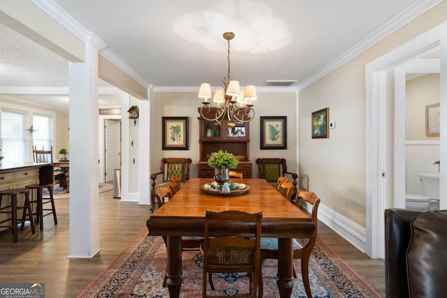 dining room with crown molding, dark hardwood / wood-style floors, and a notable chandelier