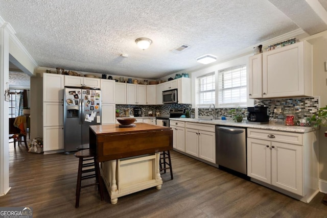 kitchen featuring white cabinetry, sink, stainless steel appliances, dark hardwood / wood-style flooring, and crown molding